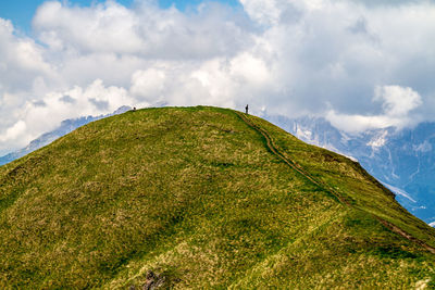 Low angle view of green mountain against sky