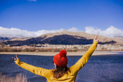 Rear view of woman in hat against mountain range