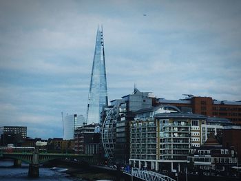 View of cityscape against cloudy sky