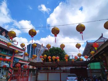 Low angle view of lanterns hanging against sky