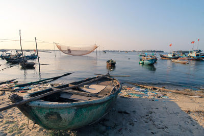 Vietnamese fishing boats moored on beach against clear sky