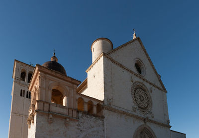 Low angle view of bell tower against clear blue sky