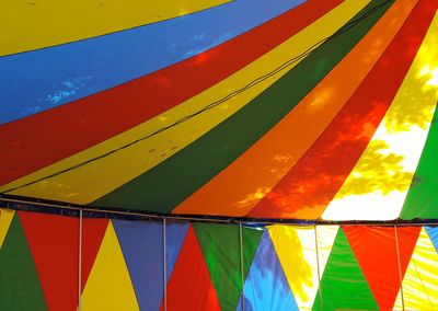Close-up of colorful umbrella against blue sky