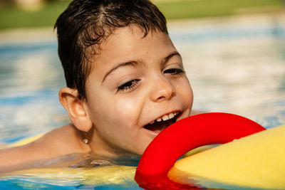 Close-up portrait of smiling boy in swimming pool