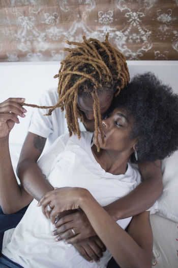 Lesbian couple embracing on bed