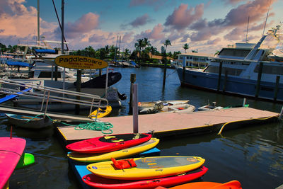 Boats moored at harbor against sky