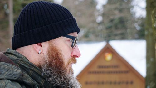 Close-up of man wearing eyeglasses and knit hat during winter