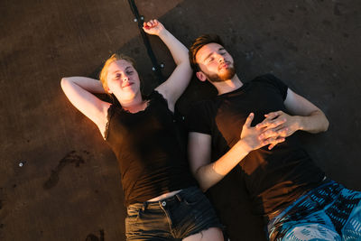 High angle view of couple lying on boardwalk