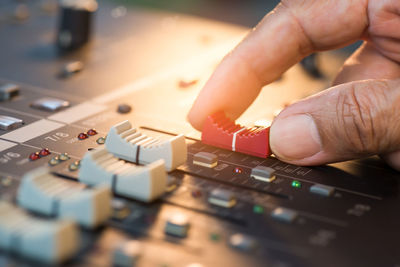 Cropped hand of person using sound mixer
