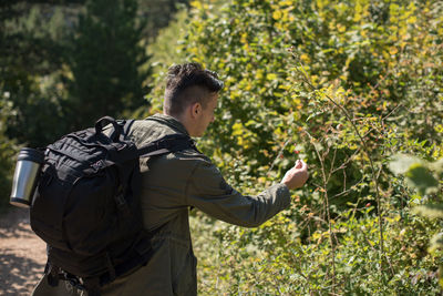 Young man standing by plants