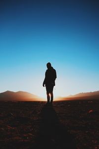 Man standing on landscape against clear sky