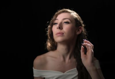 Woman looking away against black background