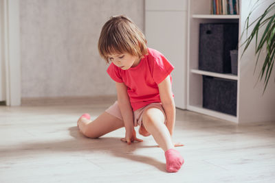 Child trains at home and learns to sit on the twine. the concept of health, sports, learning online