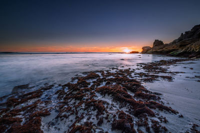 Scenic view of sea against clear sky during sunset