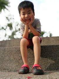 Portrait of smiling girl sitting outdoors