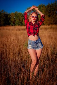 Portrait of young woman standing on field