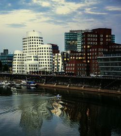 River by buildings against sky in city