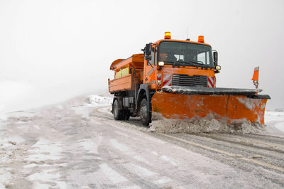 Construction vehicle cleaning snow on road
