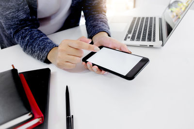 Midsection of woman using laptop on table