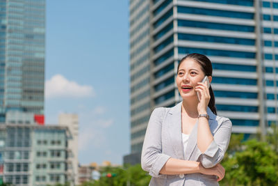 Young woman using mobile phone in city