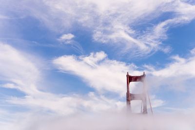 Low angle view of bridge against cloudy sky