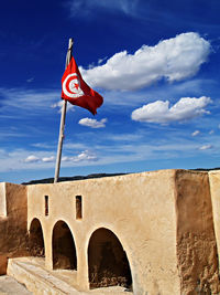 Tunisian flag on old ruin against sky