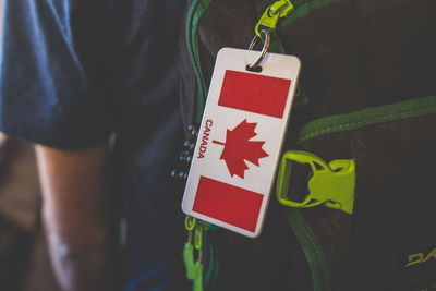 Close-up of canadian flag key ring hanging on man bag