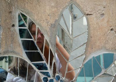 Reflection of woman on broken glass window