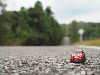 Red toy car on road in city