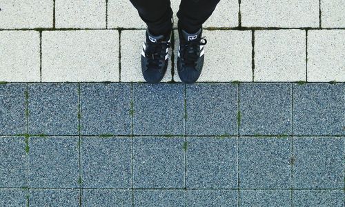 Low section of woman standing on tiled floor