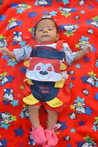 High angle view of cute baby lying on bed