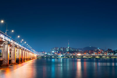Illuminated bridge over river by buildings against sky at night in korea name banpo bridge