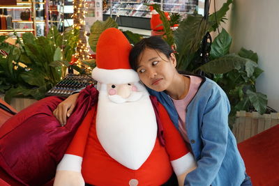 Portrait of smiling woman sitting by red indoors