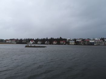 Scenic view of sea by buildings against sky