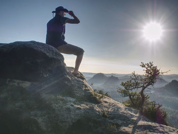 Trekker in cowboy hat enjoy view on mountain with beautiful sunrise and mist in morning mountain