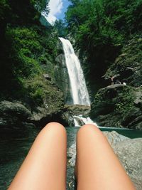Midsection of woman against waterfall 