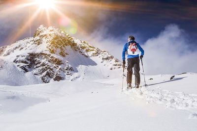 Man standing on snow covered mountain against sky