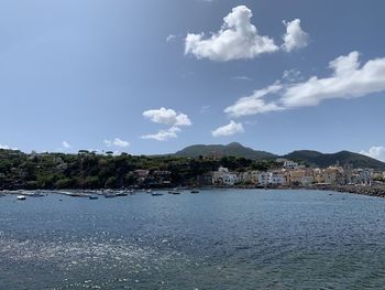 Scenic view of sea by buildings against sky