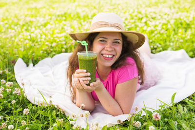 Portrait of smiling young woman drinking drink