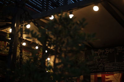 Low angle view of illuminated lighting equipment at night