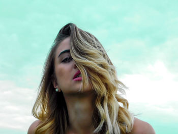 Close-up of beautiful woman against sky