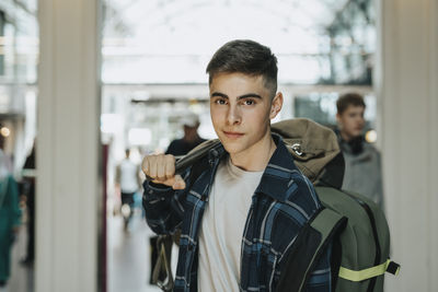Portrait of teenage boy with luggage at station