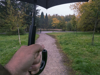 Person holding umbrella on field during autumn
