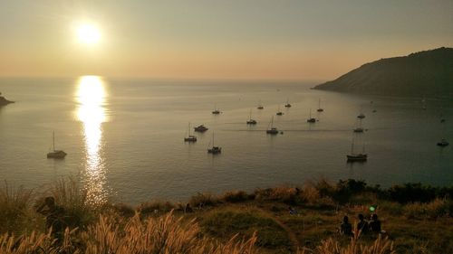 Scenic view of sailboats in sea against sky during sunset