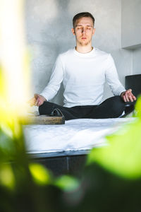 Portrait of young man sitting on table