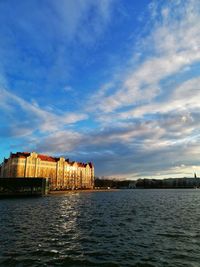 Buildings by sea against sky