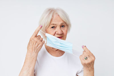 Portrait of woman holding paper currency against white background
