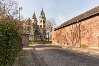 Footpath amidst buildings against sky