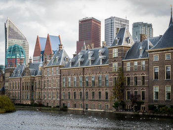 Buildings in city against cloudy sky