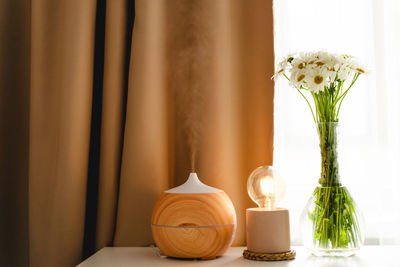 Aromatherapy concept. aroma oil diffuser on the table against the window.